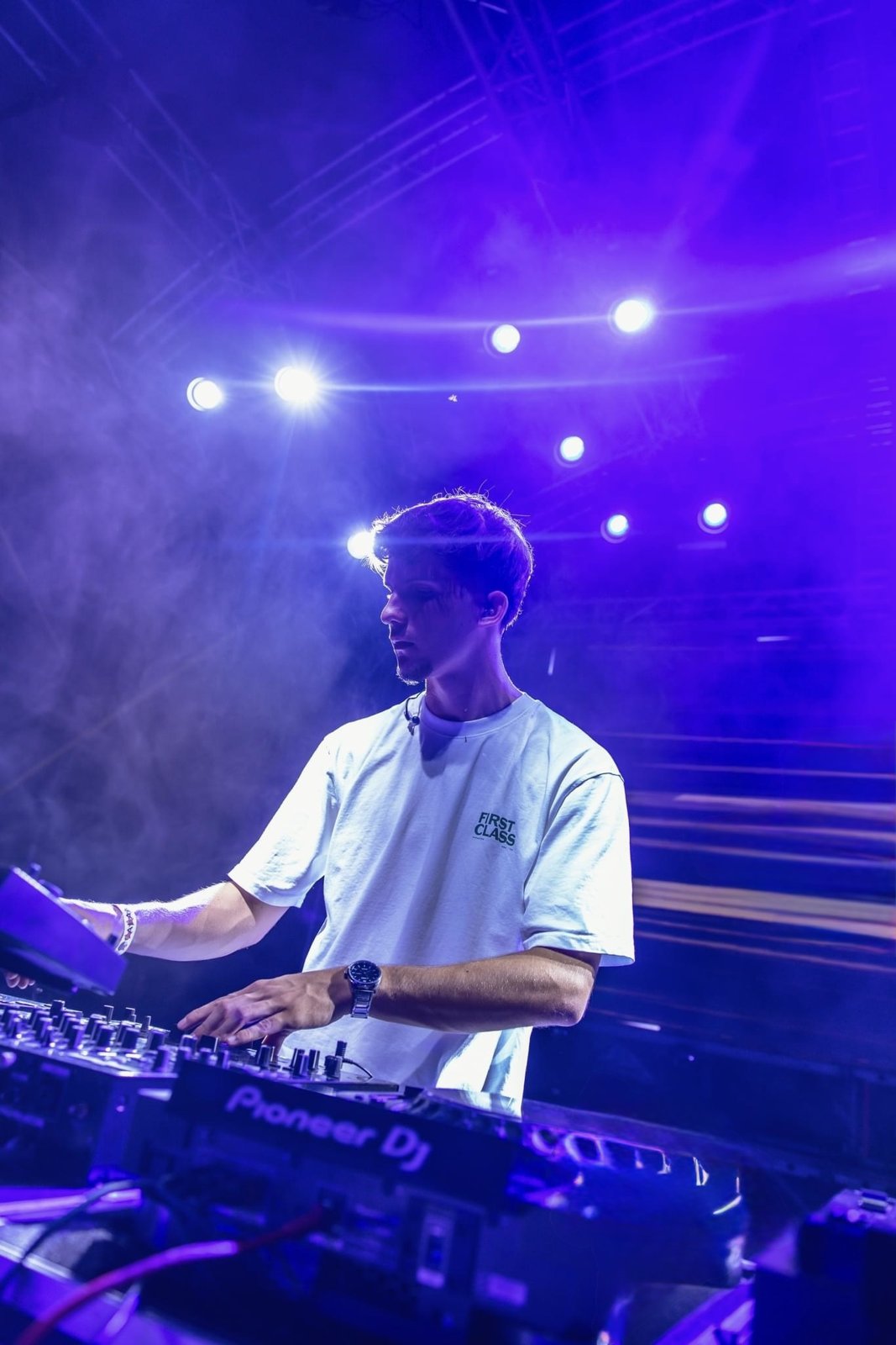 Thomas Thesseling DJing on stage under purple lights